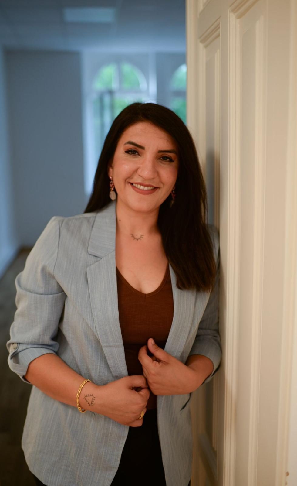 Ayla Simsek Sagir steht lächelnd an einem Türrahmen